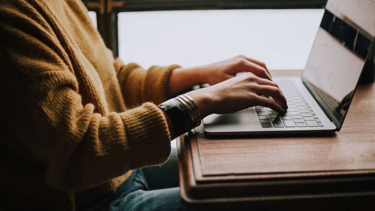An image of a person typing on their computer