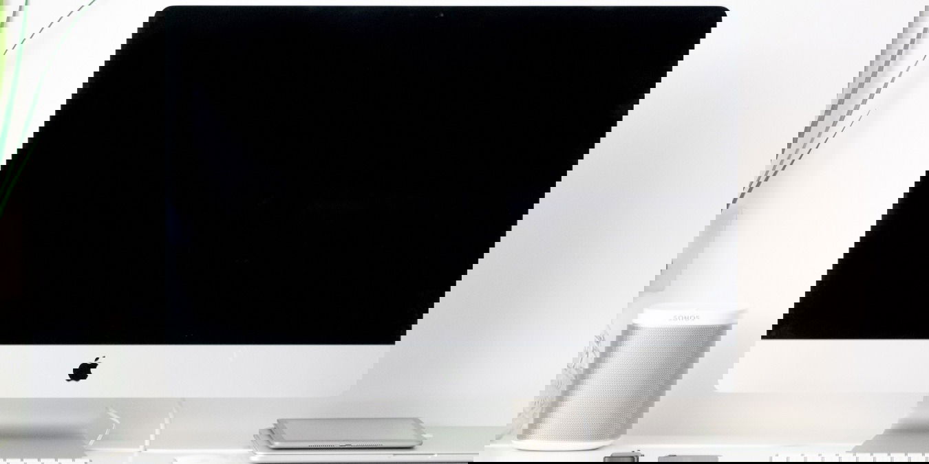 Photo of a Mac perched on a desk next to a plant