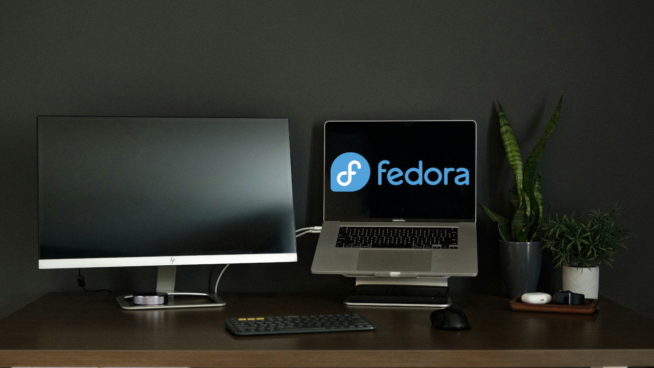 A photograph showing a laptop and a monitor screen on top of a table.